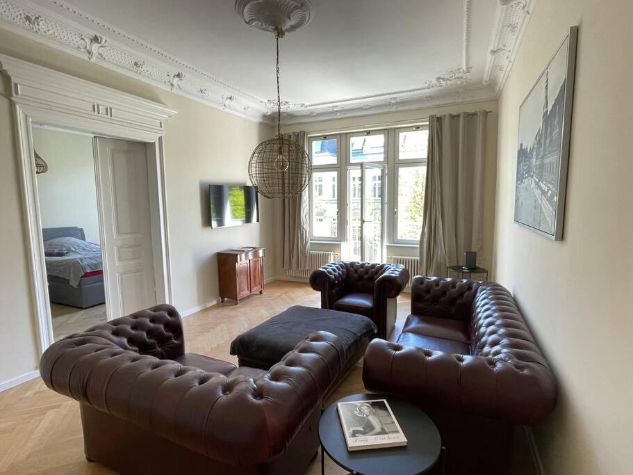 莱比锡Ruhige&charmante Altbauwohnung的客厅配有真皮沙发和两把椅子