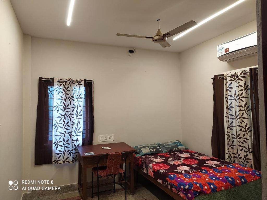 维沙卡帕特南Anve's Airport Nest的一间卧室配有一张床、一张桌子和一个窗户。
