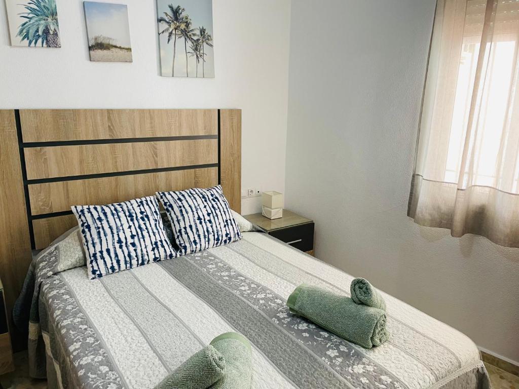 科尼尔-德拉弗龙特拉Apartamento Conil Playa & Centro, perfecto descanso, con Aire Acond y WIFI的一间卧室配有一张床,上面有两条毛巾