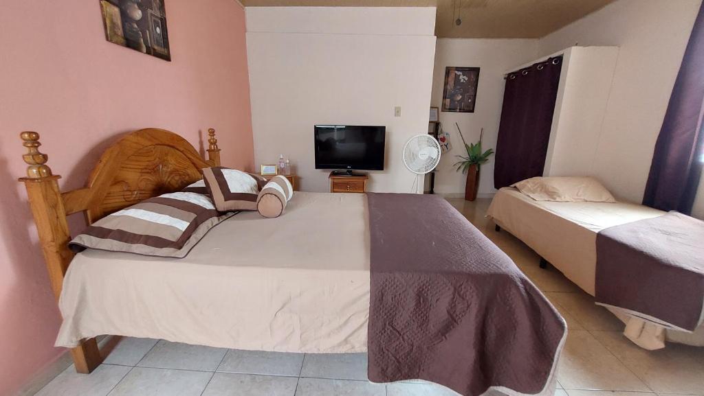 CabuyaTocumen Sweet Home的一间卧室配有两张床和一台平面电视