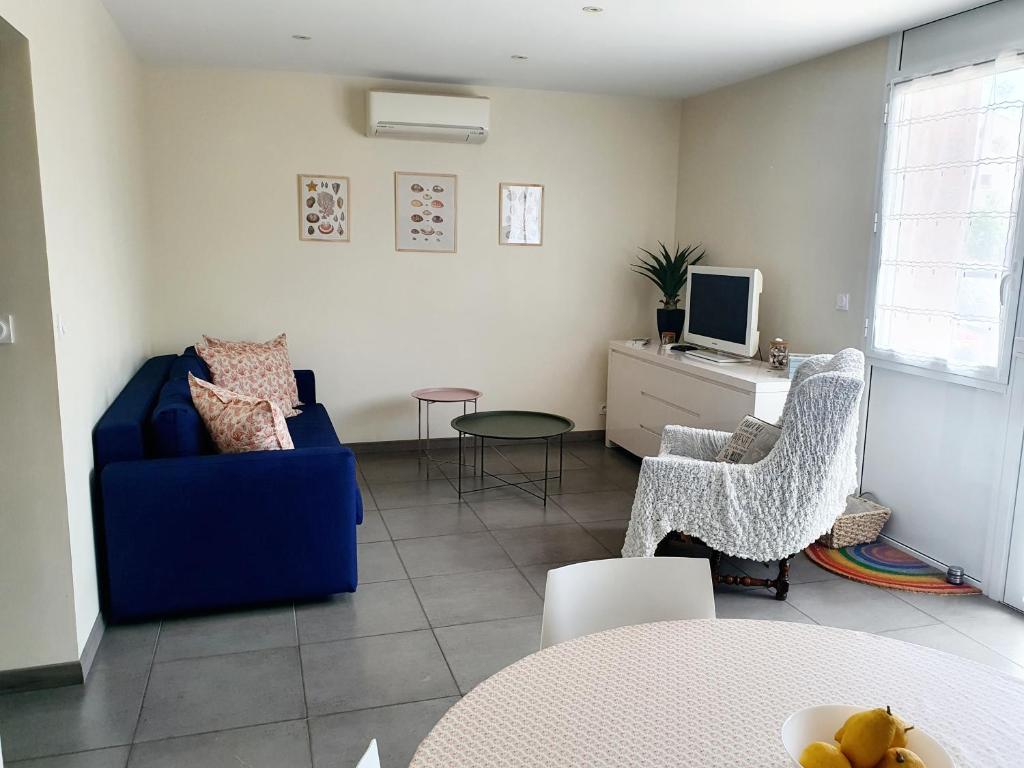 BompasAppartement plein pied climatisé dans maison catalane的客厅配有蓝色的沙发和椅子