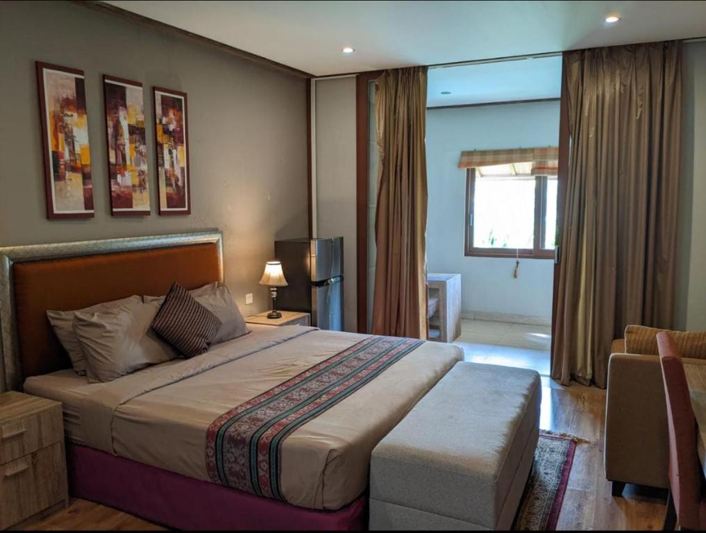 金巴兰普瑞萨比那住宿加早餐旅馆的一间卧室配有一张床、一张沙发和一个窗口