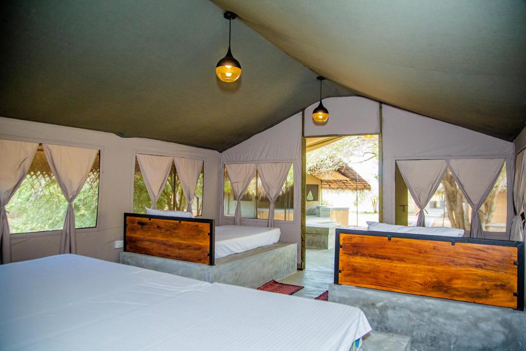 蒂瑟默哈拉默Yala Wild Hut - Yala的一间卧室设有两张床和两个窗户。
