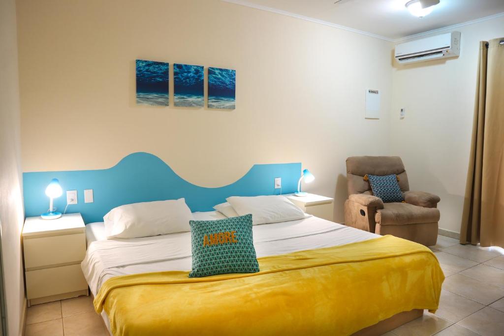 克拉伦代克Aqua Viva Suites的一间卧室配有一张大床和一把椅子