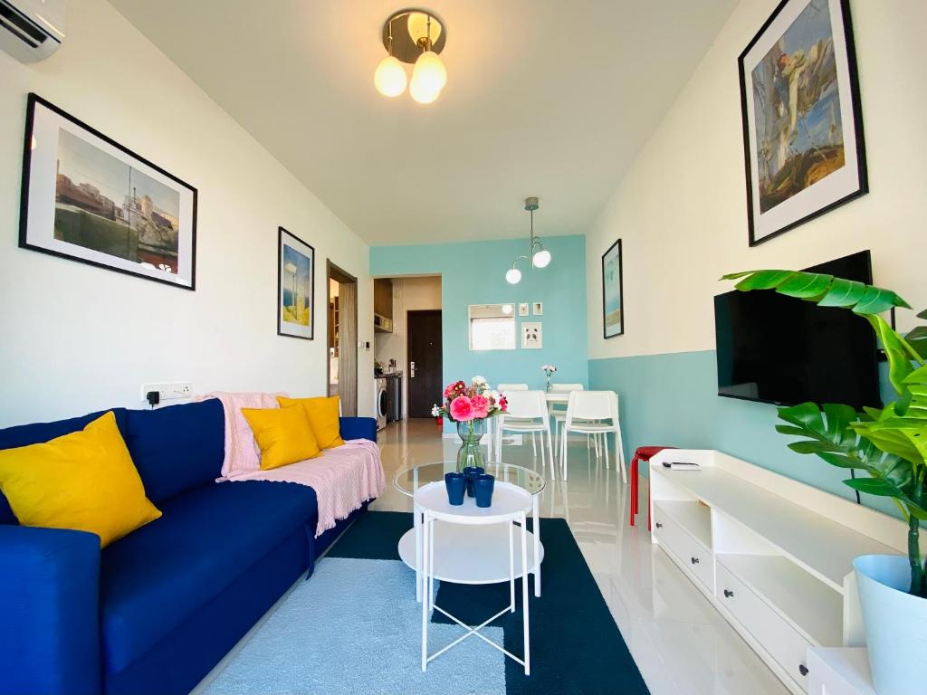 振林山SeaView 2-bedroom Fully Furnished Apartment Forest City #freeWIFI的客厅配有蓝色的沙发和电视