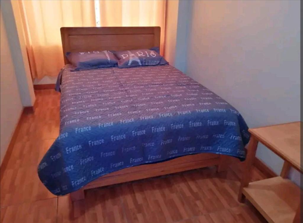普诺Hospedaje Sumita Wasi的一间卧室配有一张带蓝色棉被的床