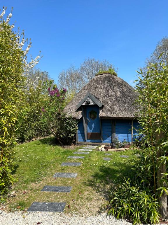 翁弗勒尔Aux murmures de la nature的蓝色的房子,有茅草屋顶和一条小径
