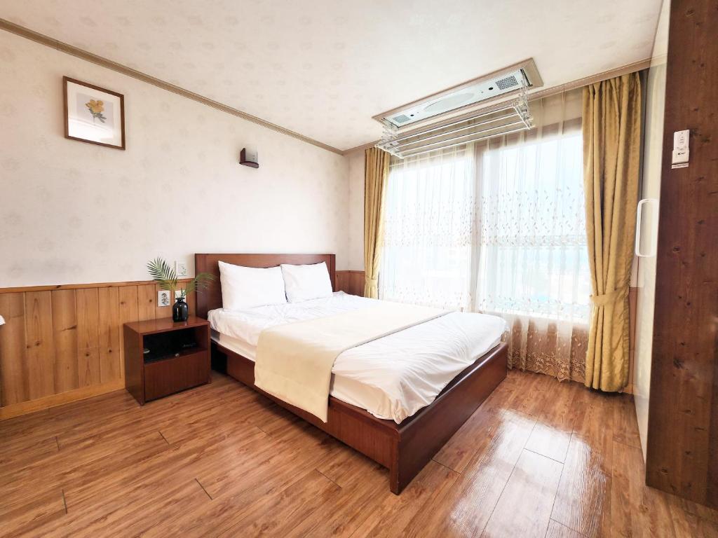 西归浦市君姆海桑帕克特尔度假屋的一间卧室设有一张大床和一个窗户。