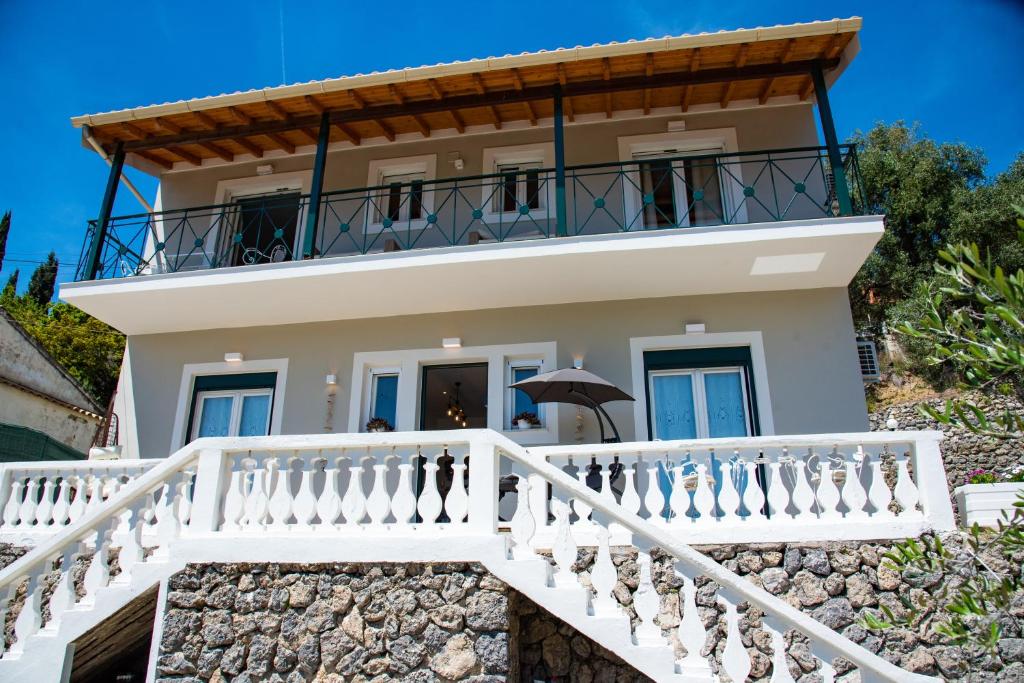 帕莱欧卡斯提撒Nausika Rustic Cottage的带阳台和楼梯的白色房屋