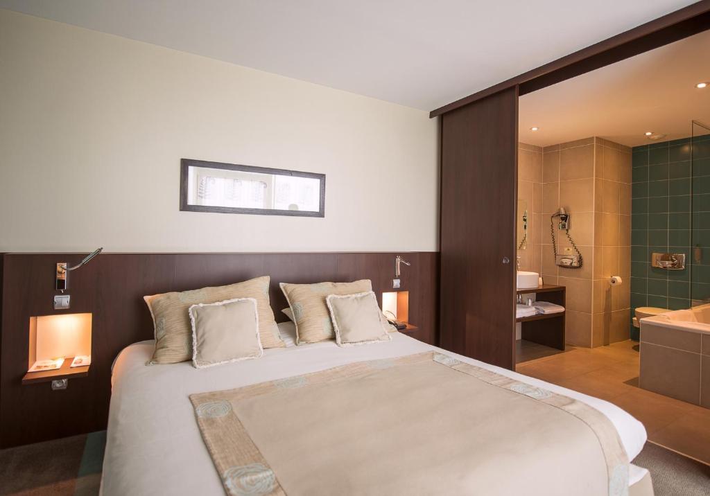 圣阿芒莱索帕斯诺酒店的一间带大床的卧室和一间浴室