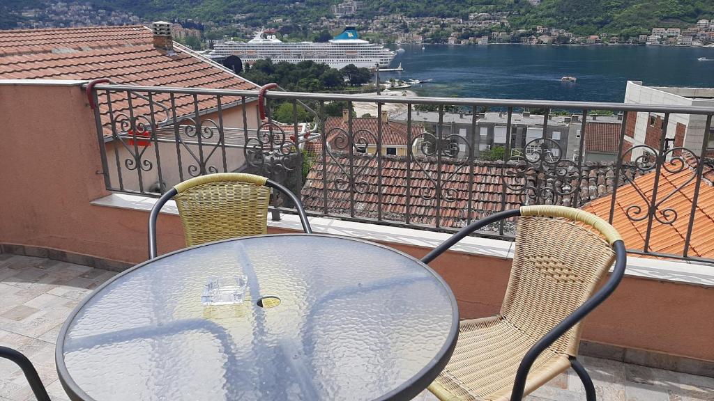 科托尔Apartments Krivokapic Kotor的阳台上的玻璃桌和两把椅子