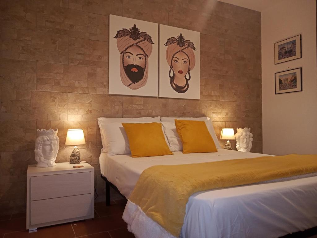 巴勒莫Zisa Home ai Cantieri Culturali的卧室配有一张床,墙上挂有两张照片