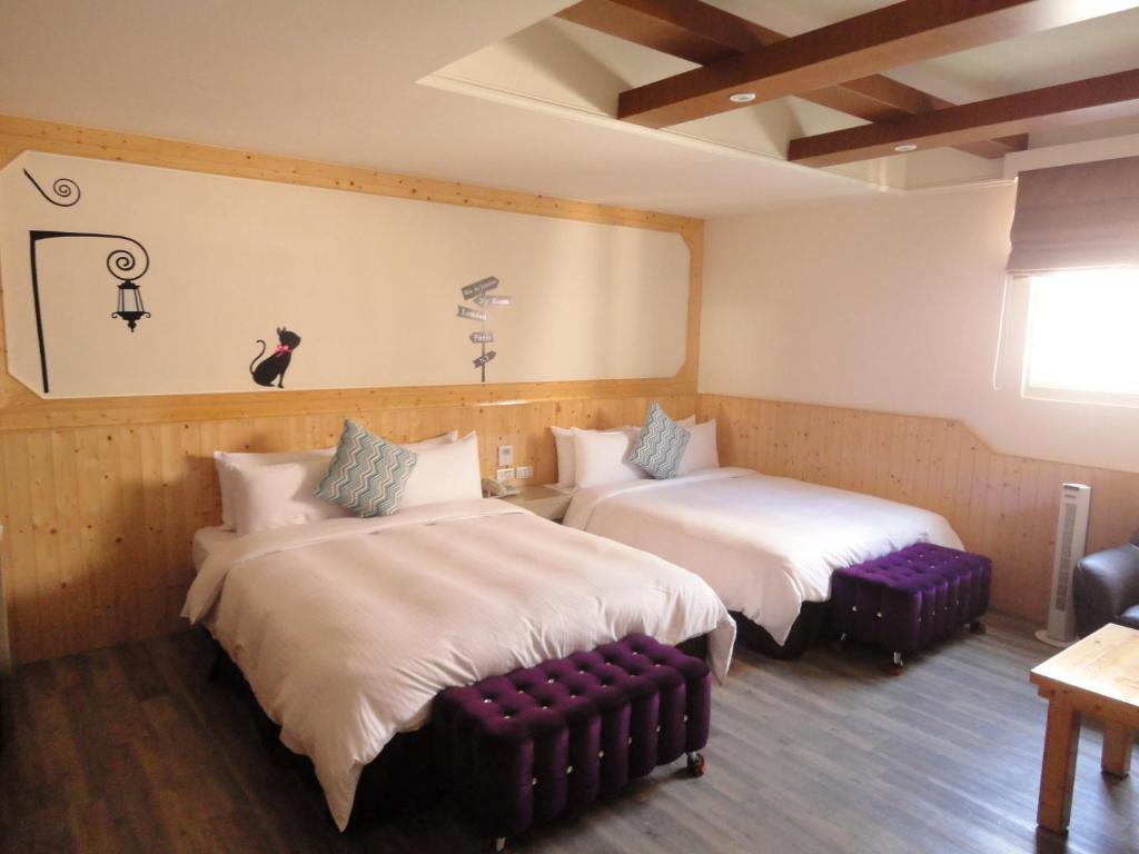 马公瑞欣大饭店的一间设有两张床和一张沙发的房间