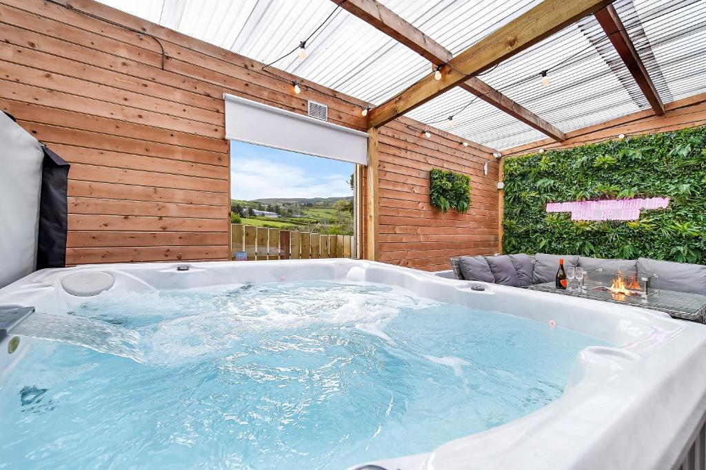 班克拉那Glenside Cottage 'Sleeping 4 guests'的木墙客房内的热水浴缸