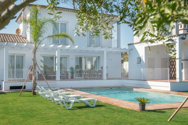 贝纳卢普-卡萨斯维耶哈斯Villa Girasol的一个带躺椅的游泳池以及一座房子