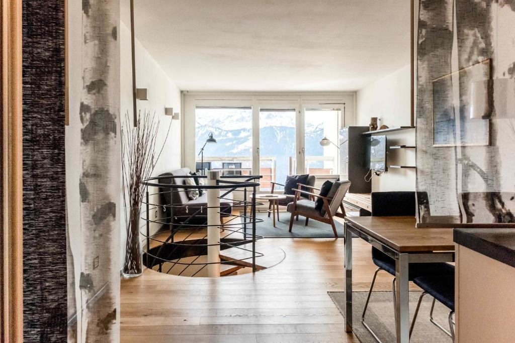 贝阿滕贝格Apartment Alpenrose 2.5 mit Mitbenutzung SPA & Wellness - GRIWA RENT AG的厨房以及带桌椅的起居室。