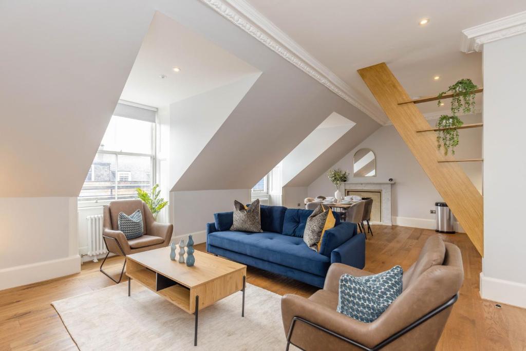 爱丁堡Dragon Suites - Ladon Suite - 2 bed city centre luxury apartment的客厅配有蓝色的沙发和椅子