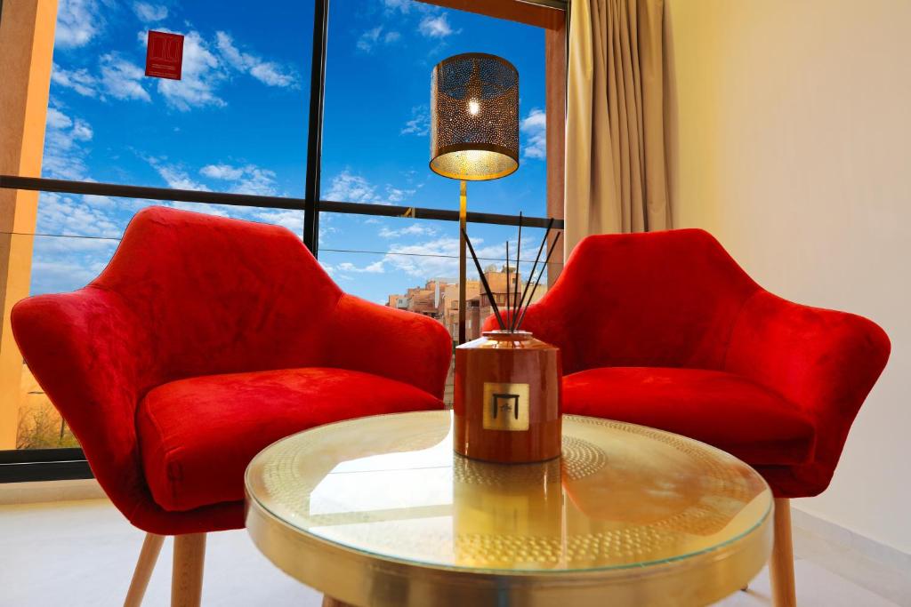 马拉喀什Ari Boutique Hôtel - Adult Only的窗前的两张红色椅子和一张桌子