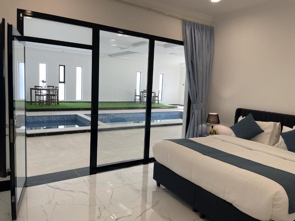 Al QābilBedyiah Green Homes的一间卧室设有一张床和一个游泳池