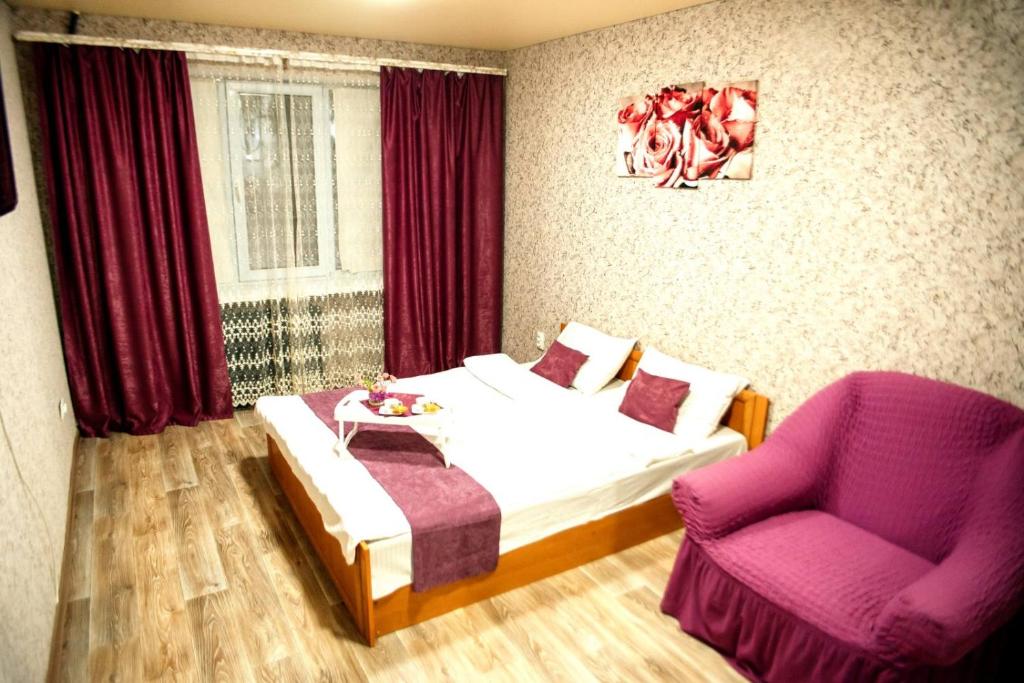 乌曼岛Затишна квартира в центрі, ближче до Софіївського парку.的一间卧室配有一张床和一张紫色椅子