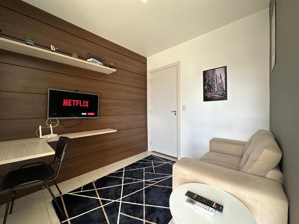 坎普斯戈伊塔卡济斯Flat aconchegante próximo a Pelinca的客厅配有沙发和墙上的电视