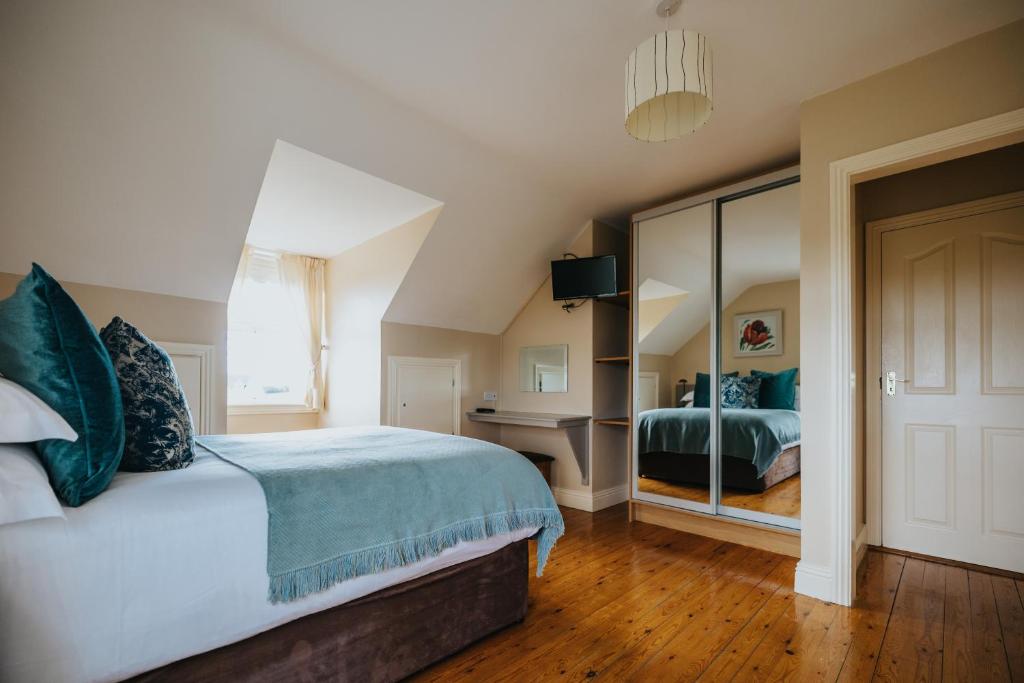 基尔基Móinéir House的一间卧室配有一张大床和镜子