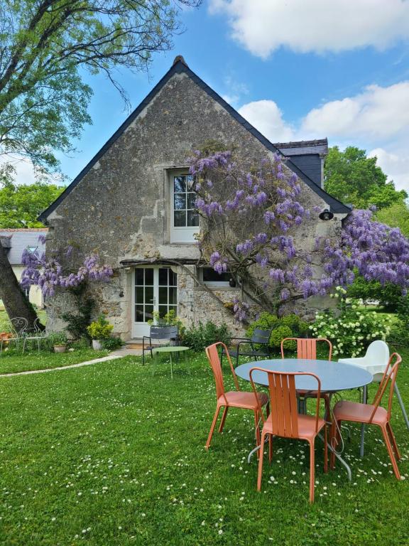 维朗德里Gîte de la bergerie的紫色花房前的桌椅