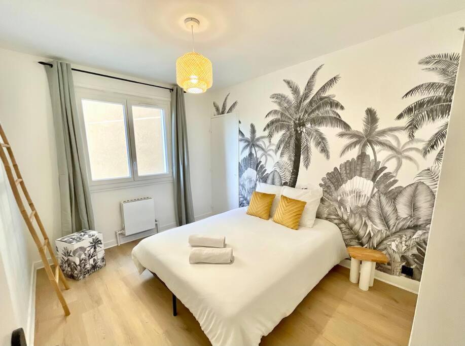 罗阿纳La Douceur Roannaise - Parking privé proche gare的卧室配有一张大床,墙上挂着棕榈树