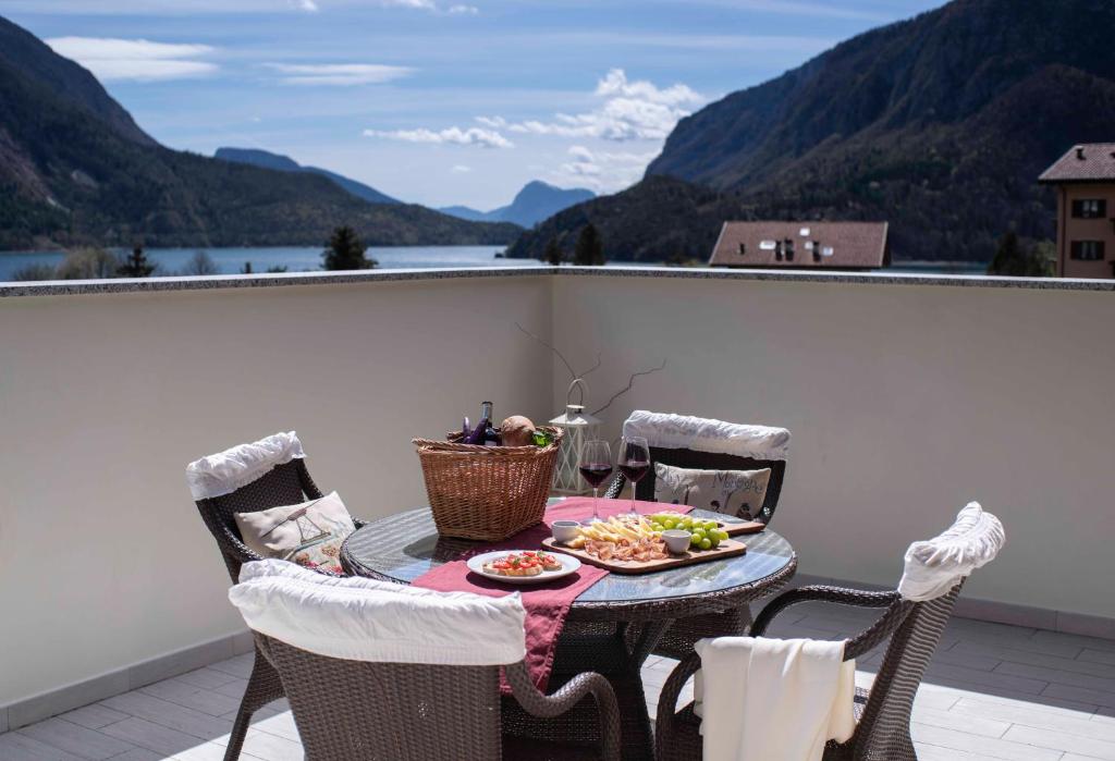 莫尔韦诺Attico con vista sul lago e montagne a Molveno的阳台上的餐桌上放着一盘食物