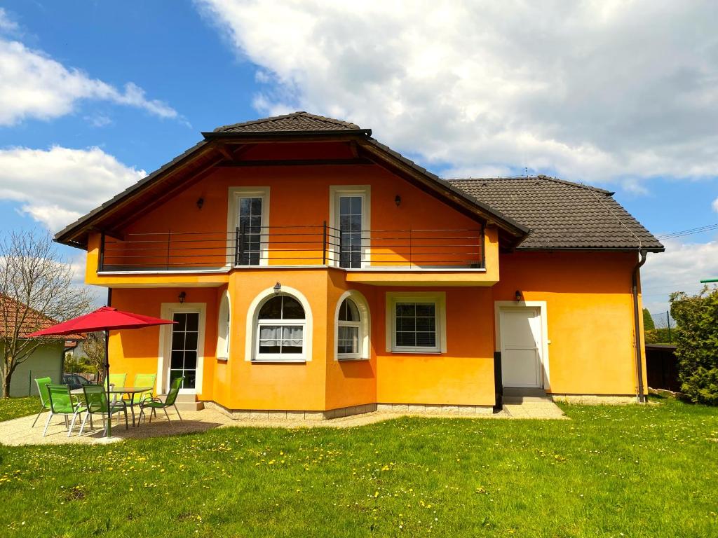 Rekreační chalupa Ivon的黄色和橙色的房子,配有桌子和椅子