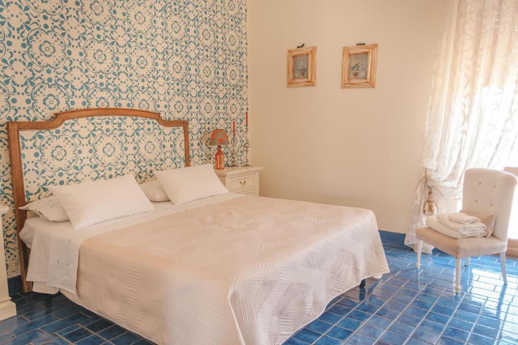 圣尼科拉阿尔切拉La casa nel borgo的卧室配有白色的床和椅子