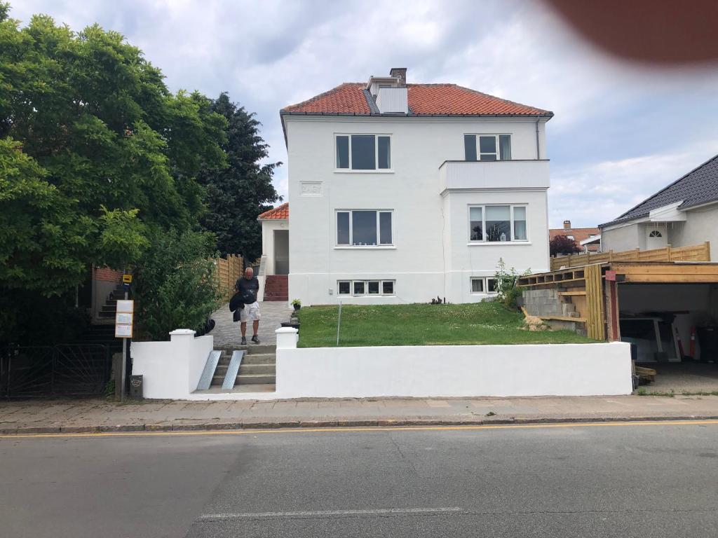 赫尔辛格Stor lys lejlighed med terrasse og altan的站在白色房子前面的人