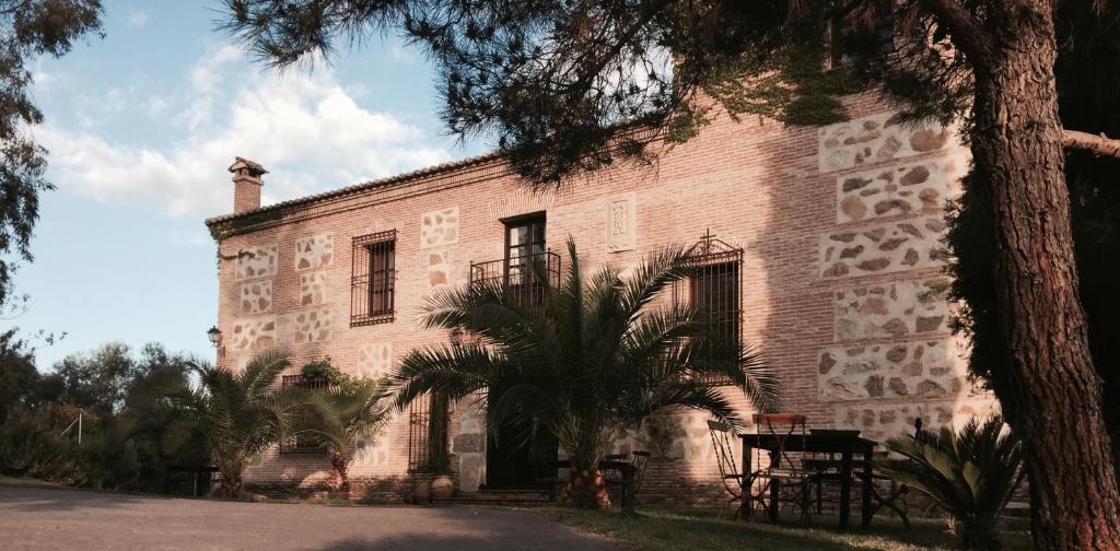 布埃纳文图拉Casa Rural Rincón de la Fuente的一座大型砖砌建筑,前面有棕榈树