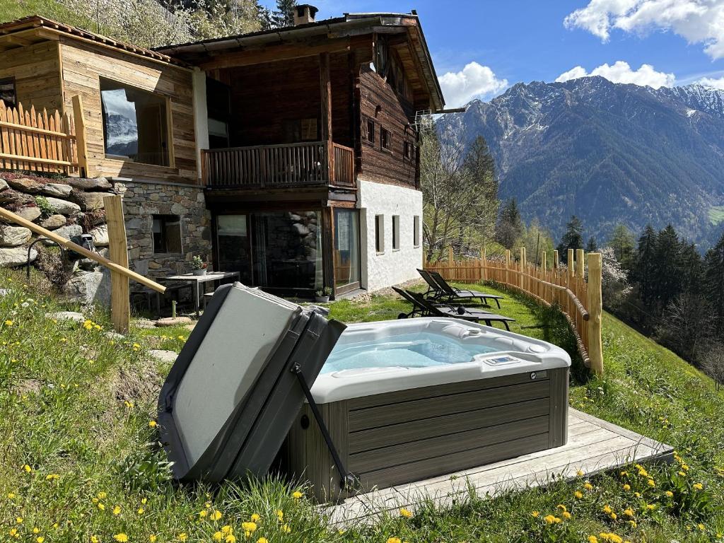 圣马蒂诺Bergchalet Obertalerhof的热水浴池和房子前的电视
