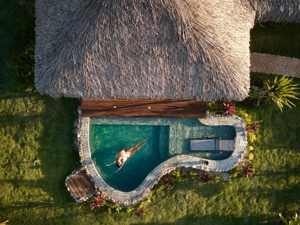 圣米格尔-杜戈斯托苏Kauli Seadi Beach Hotel的度假村水中游泳的人的空中景观