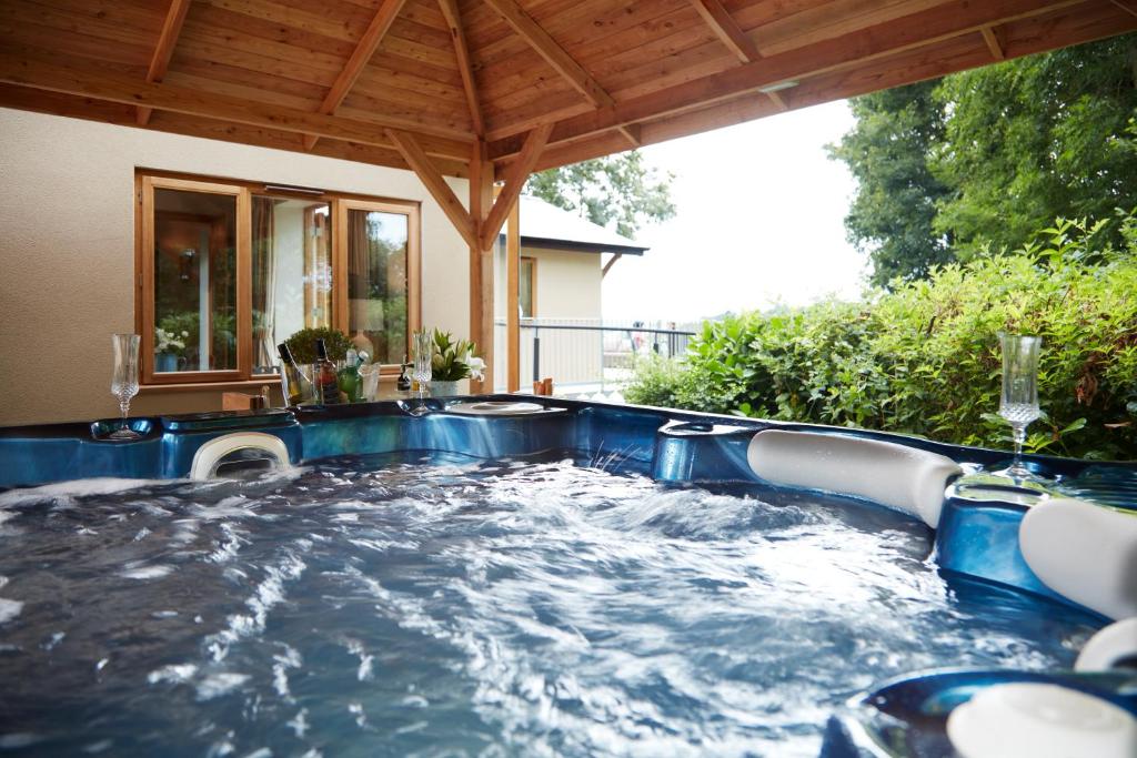 威尔斯浦Upper Gelli Luxury Holiday Lodge, Converted Dairy & Cosy Shepherds Huts的房屋后院的热水浴池