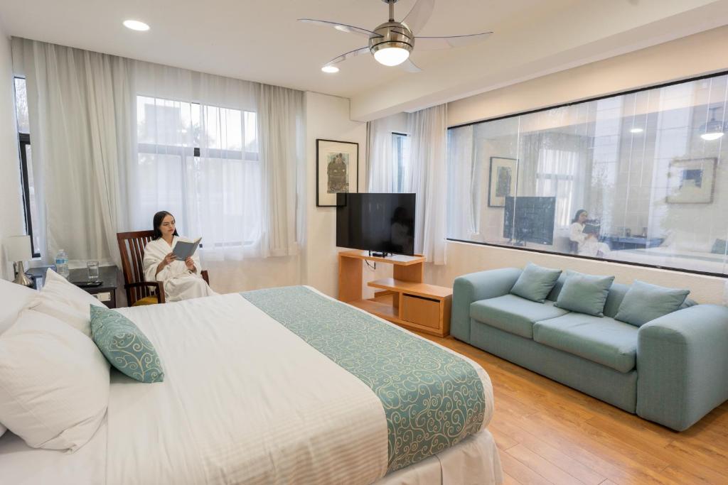 墨西哥城Suites Coben Apartamentos Amueblados的一位女士,在配有床和沙发的酒店房间
