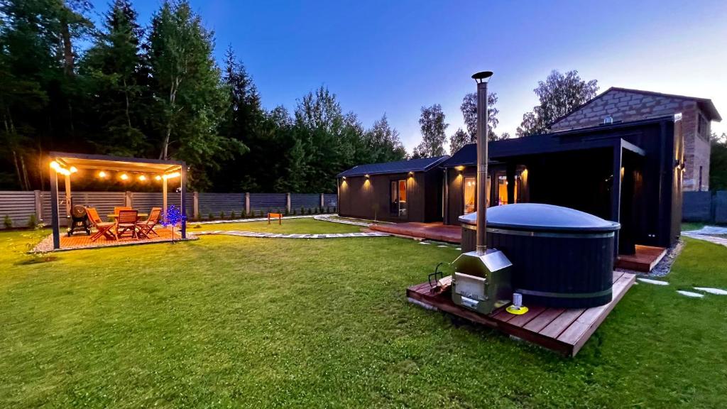 MellupiRomantic Holiday House Nandi Rezidence Janupietis的后院设有凉亭和热水浴池。