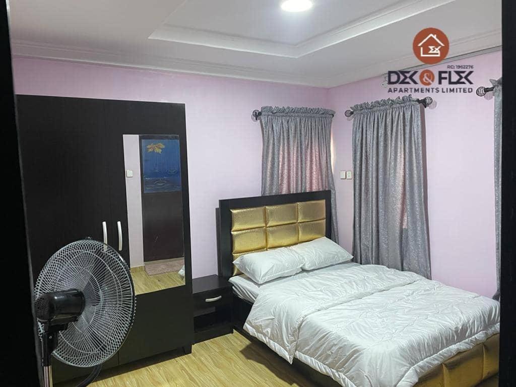 伊巴丹Dex & Flex Apartments的一间卧室配有一张床和风扇
