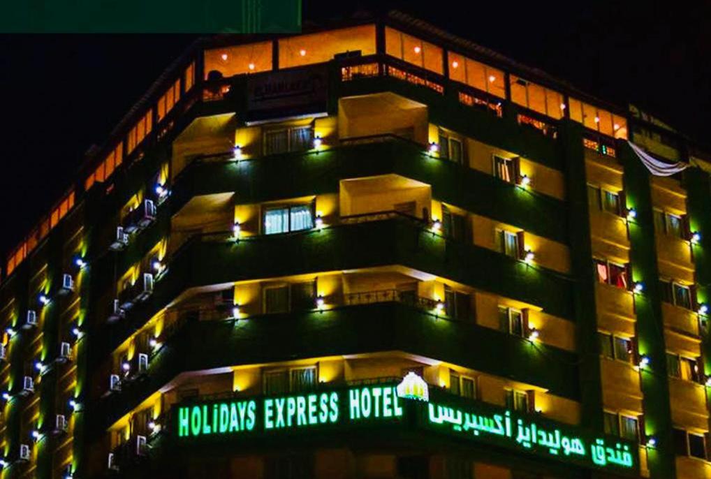 开罗假日快捷酒店的建筑的一侧有绿灯