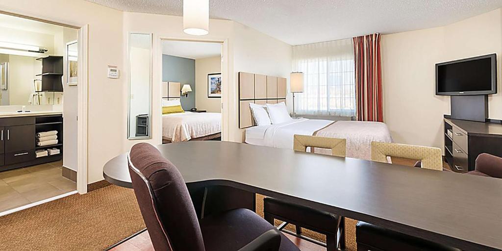 伊姆派瑞尔Sonesta Simply Suites Pittsburgh Airport的酒店客房设有书桌,房间带两张床。
