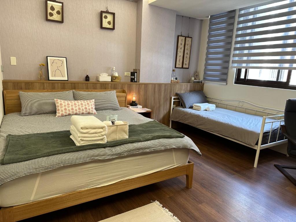 埔里三木三白包棟民宿的一间卧室配有一张床、一张小床和一把椅子
