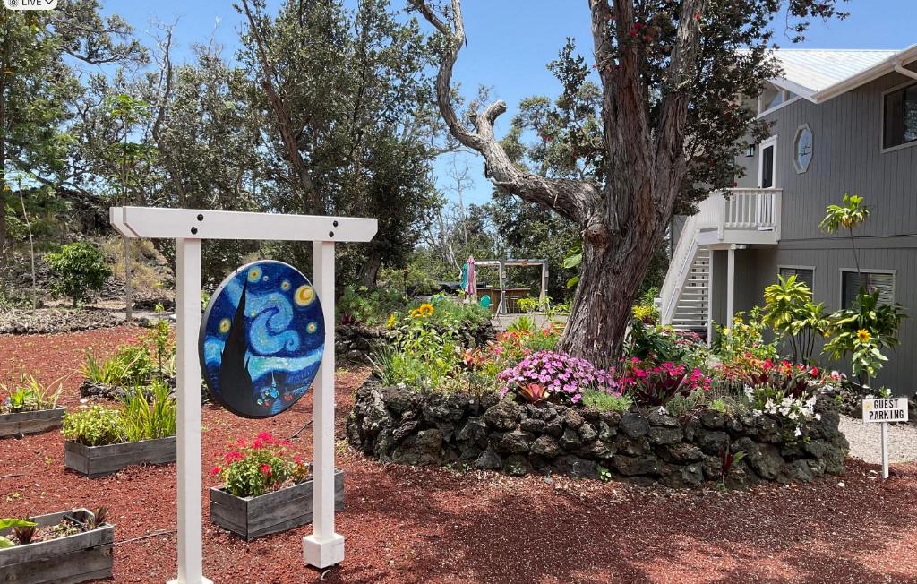 夏威夷欧申维尤The Art Garden- Hibiscus Guesthouse的花卉园前的标志