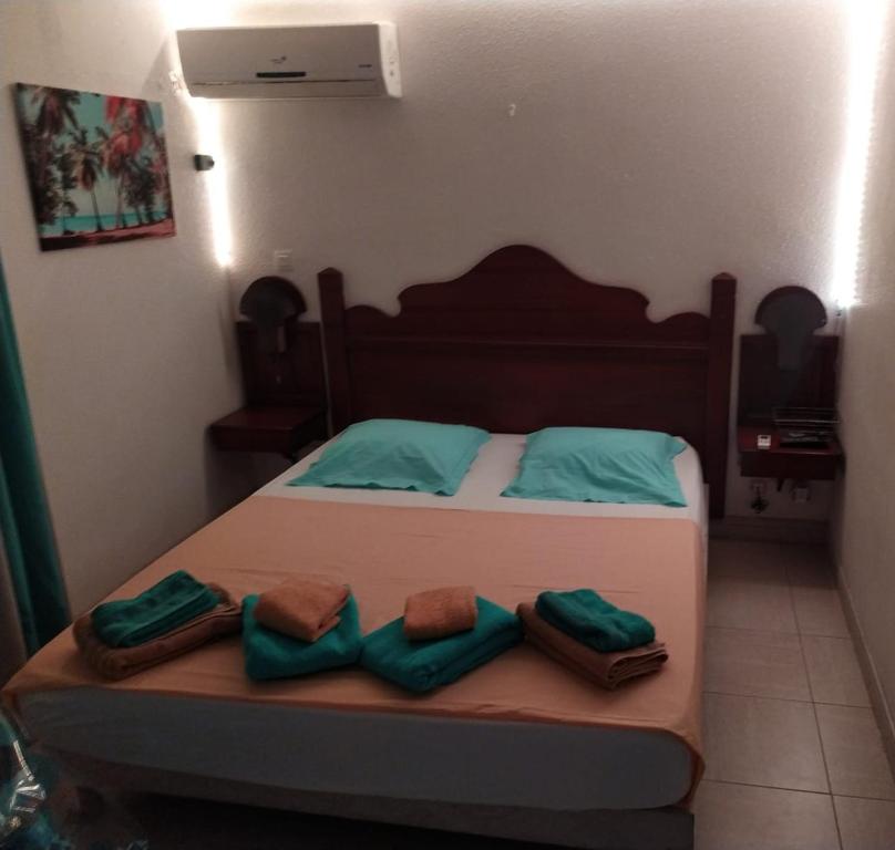 圣安娜La Martiniquaise的一间卧室配有一张带绿色枕头的床。
