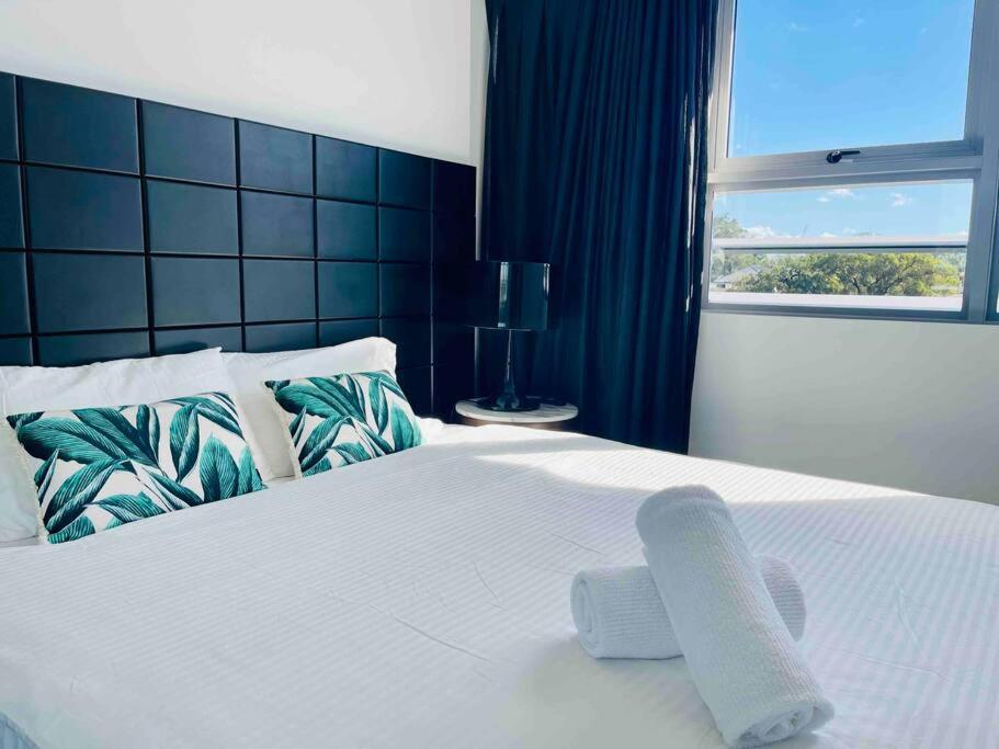悉尼Sydney Executive Apartment 3beds2baths parking Chatswood的卧室配有白色的床和窗户。