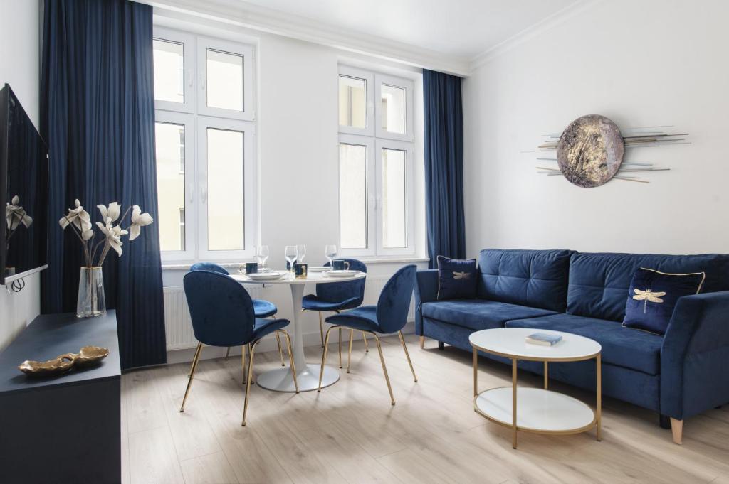 托伦Manpro Apartments Toruń的客厅配有蓝色的沙发和椅子