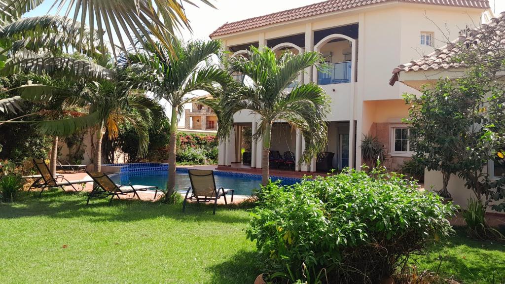 萨利波图尔villa térangart saly的一座别墅,设有游泳池和棕榈树