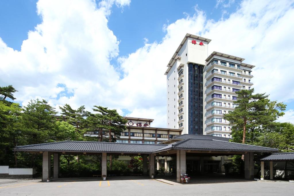草津草津温泉樱井酒店(Hotel Sakurai)的大楼前有停车位的酒店