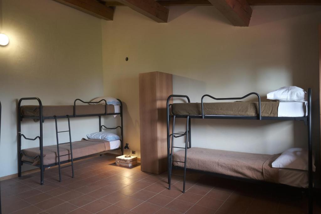 FalcianoRifugio Valomagna的铺有瓷砖地板的客房配有两张双层床。