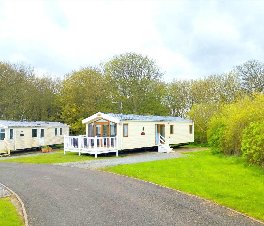 TunstallSand Le Mere Holiday Village Caravan hire的路边的几栋移动房屋